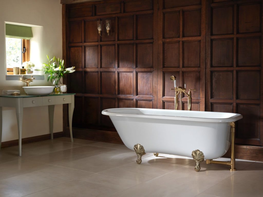 Victorian style dark wood paneled bathroom with a clawfoot tub